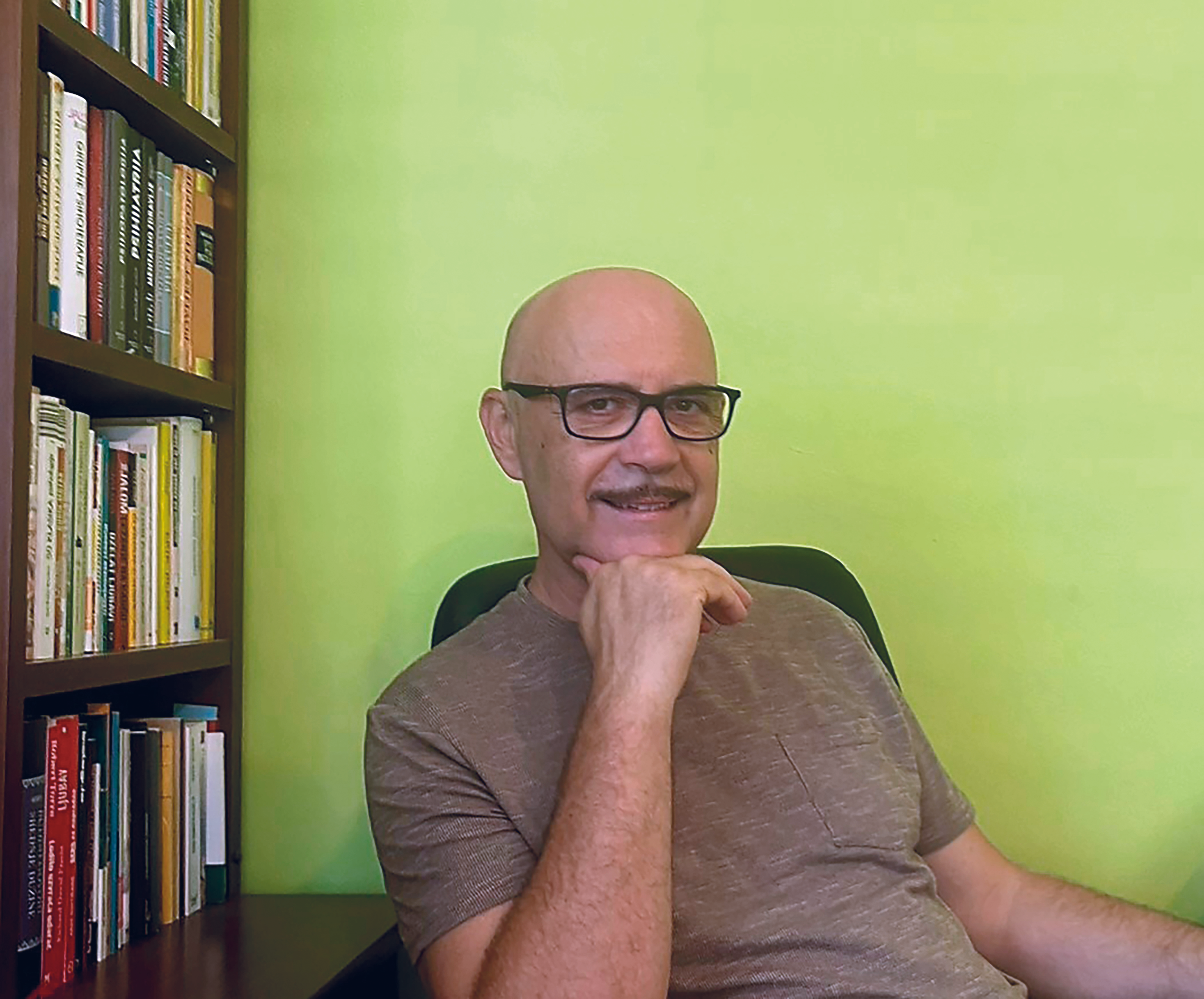 Miro Božić sjedi u uredu ispred police s knjigama, u opuštenoj atmosferi.